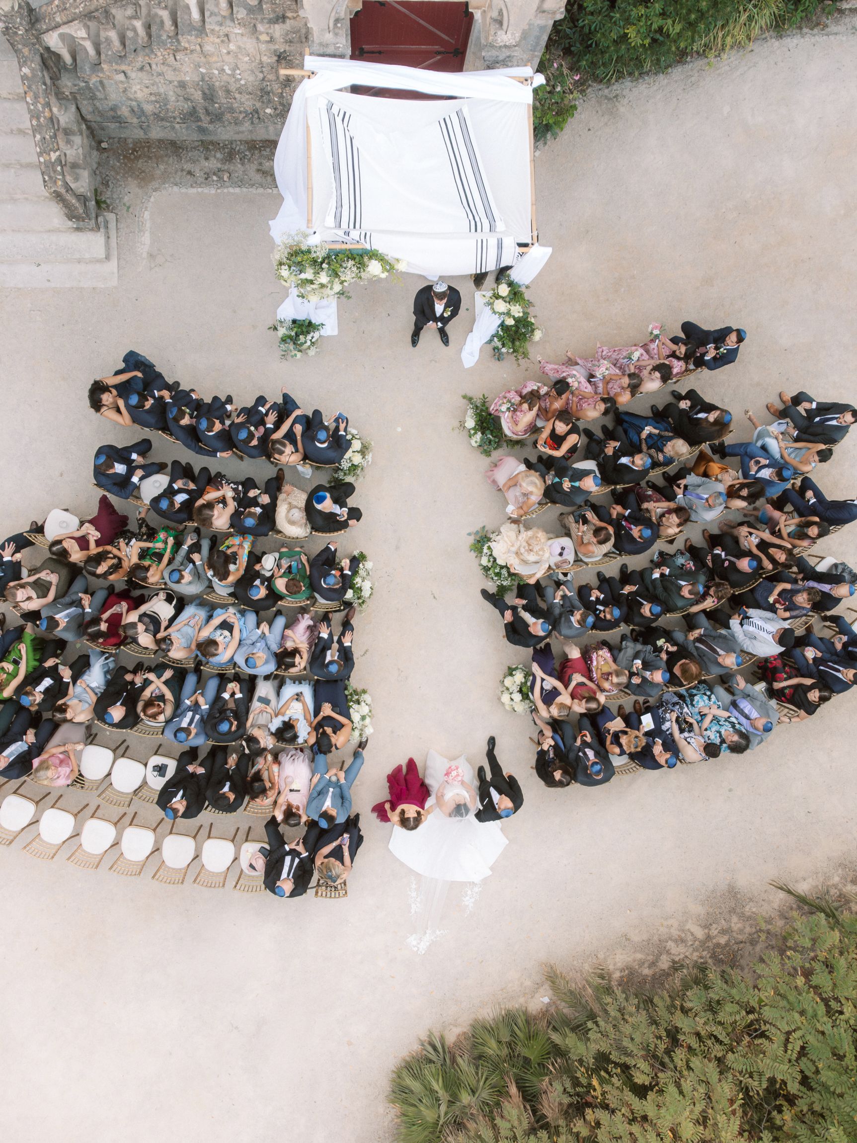 Aerial view of Jewish wedding ceremony under chuppah at Forte da Cruz in Cascais Portugal