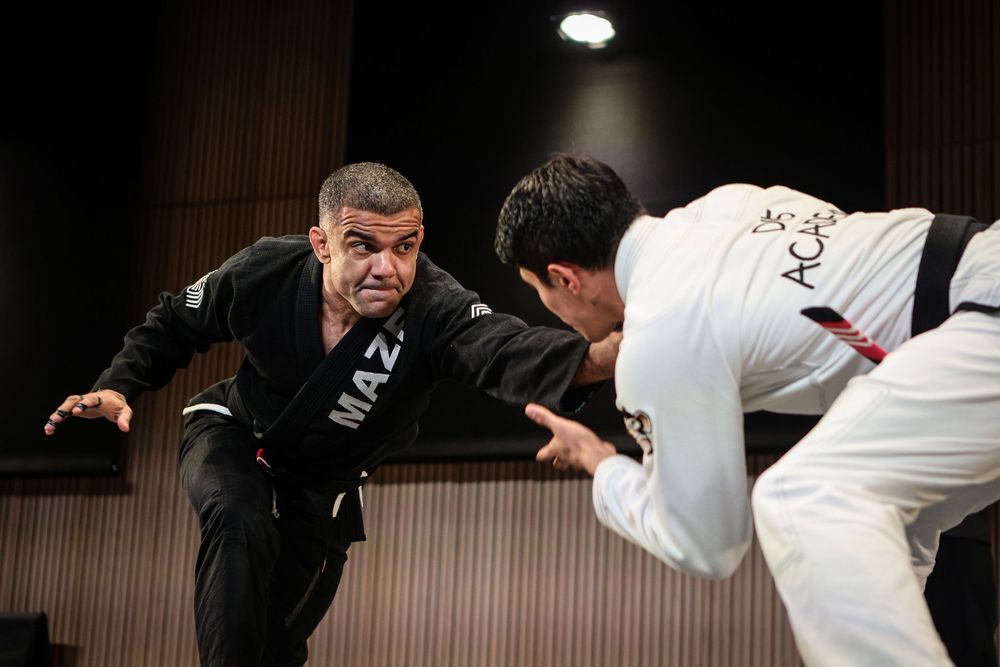 Two BJJ practitioners sparring in gi and no-gi attire during an intense training session.
