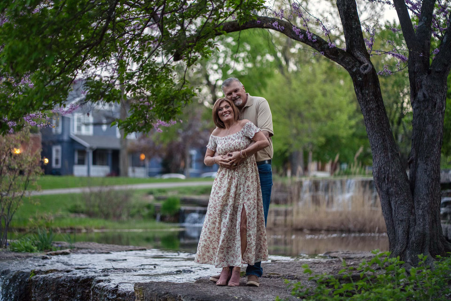 Couple embracing outdoors near a pond, at  Franklin Park Conservatory for your elegant Engagement Photos