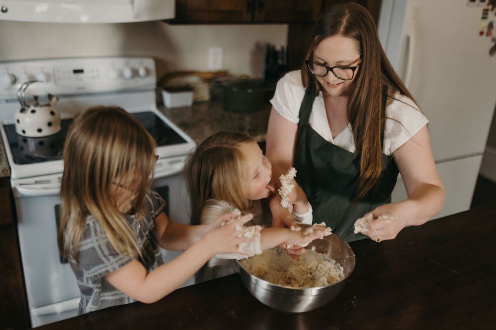 Woman and two girls mixing ingredients in a bowl together in a kitchen in Johnson City, TN.