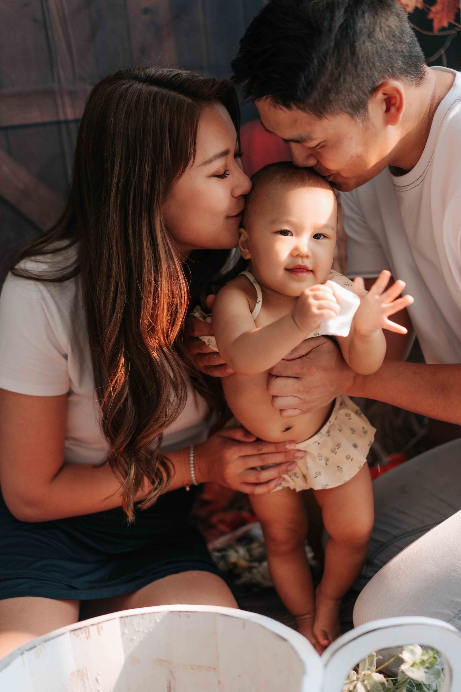 A family shares tender moments of affection and closeness while sitting together on a bed.一家人坐在床上，分享著溫馨親密的時刻。
