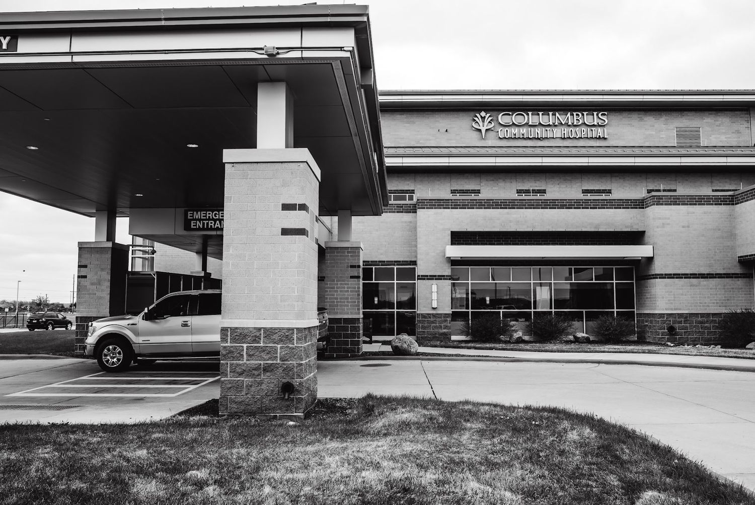 Modern medical facility exterior with entrance and parking area.