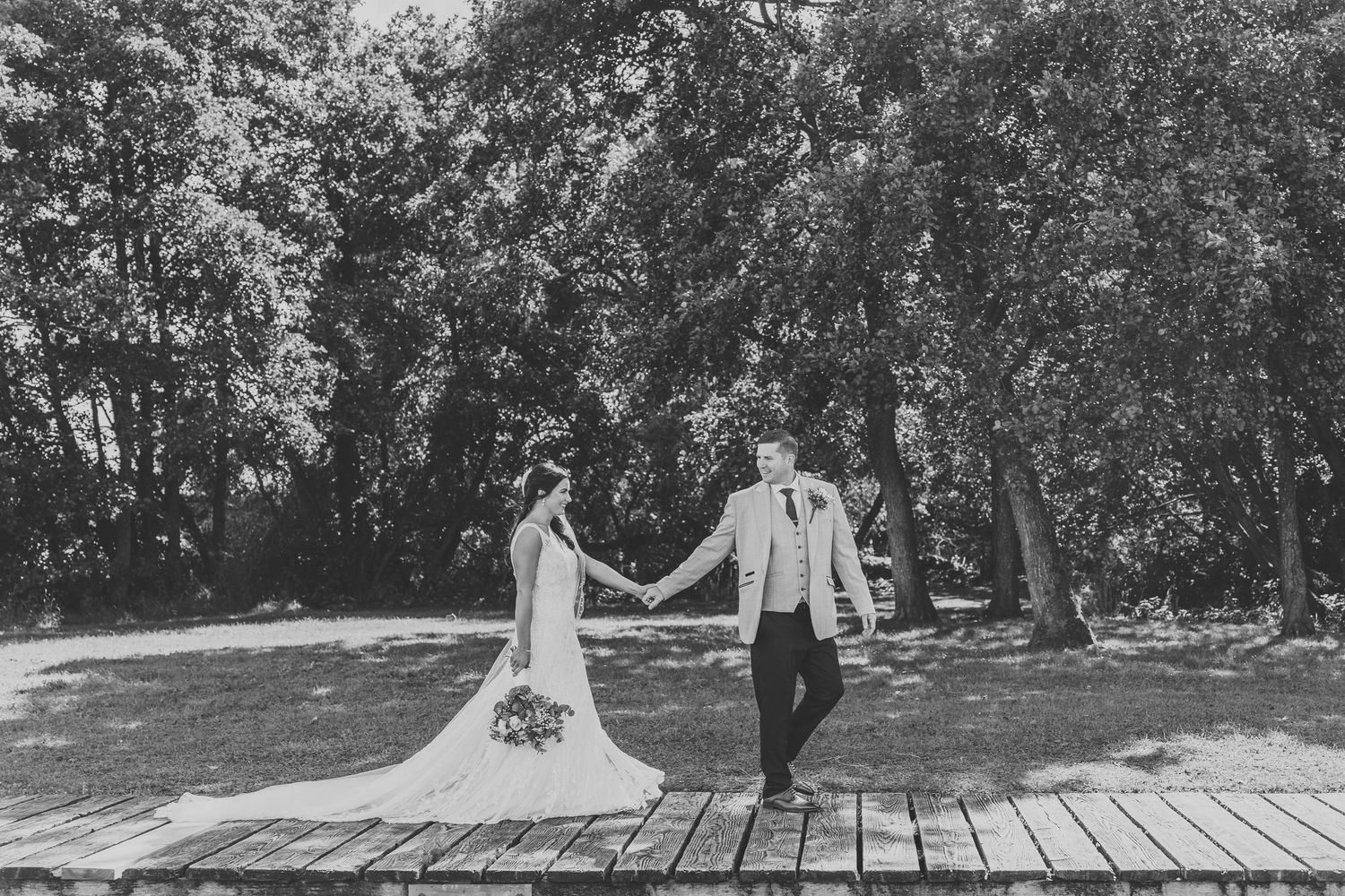 Bridal party, full of smiles, standing on steps in Tannaghmore Gardens.