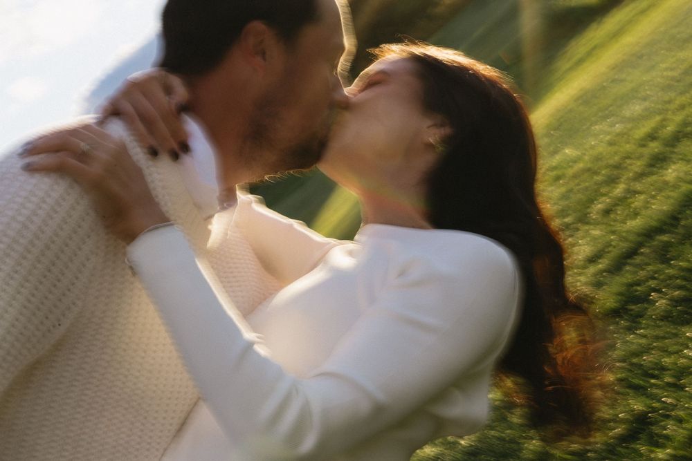 Romantic blurred image of couple about to kiss outdoors in golden sunlight.