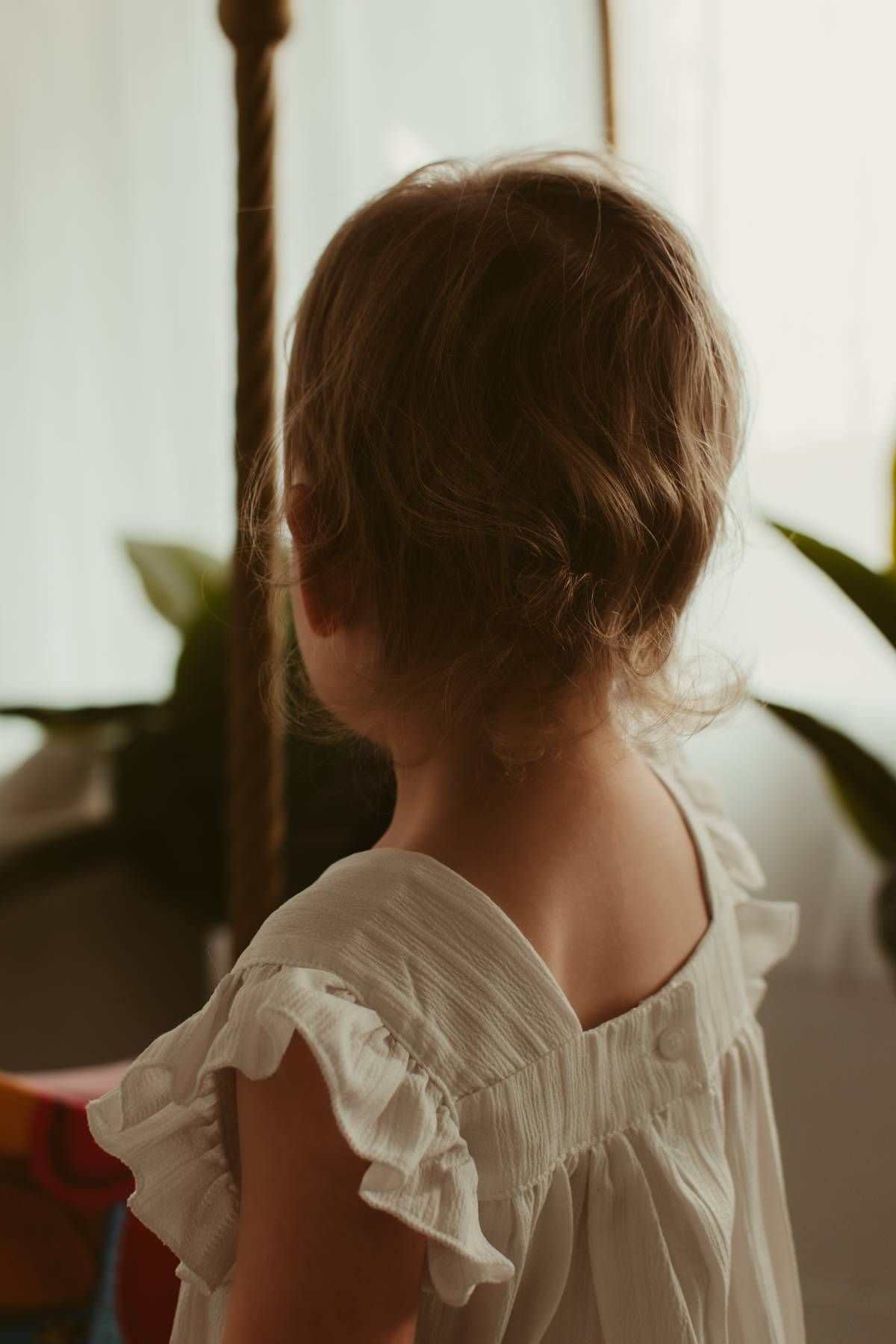 Close-up view of a person in a white ruffled blouse against a soft blurred background.