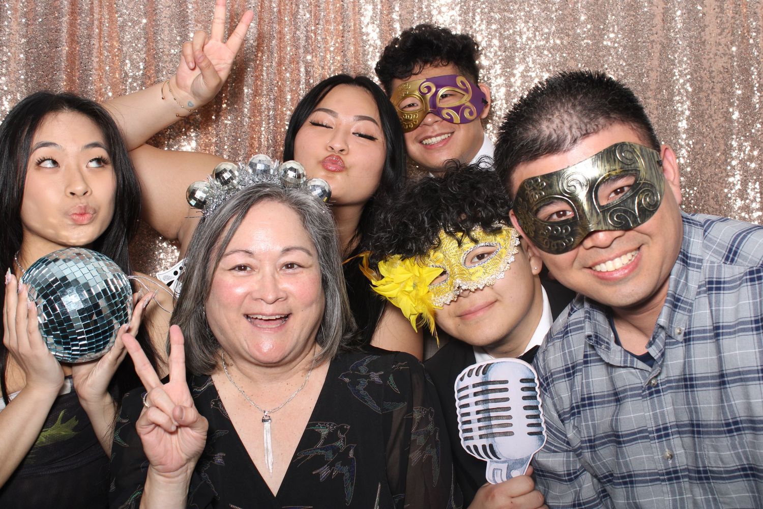 Flawless Photos captures a group posing together in masquerade masks, a disco ball and microphone against a sparkly backdrop.