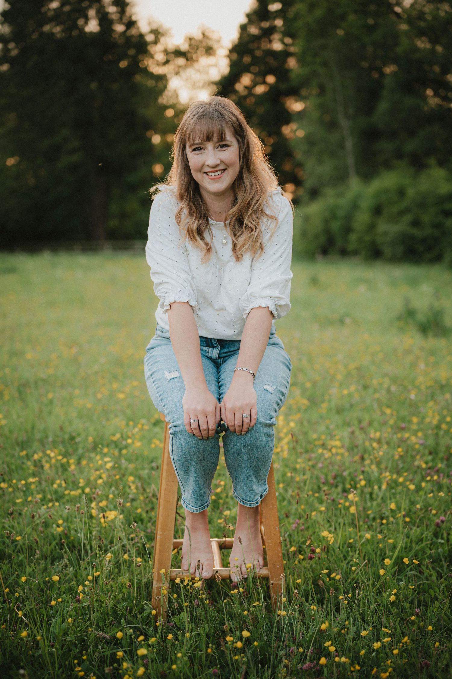 Candid portrait of Lisa from Pausing Time Photography in a wildflower meadow with yellow buttercups in Lower Slaughter Cheltenham
