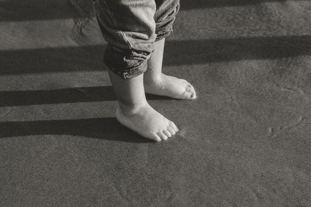 A sequence of black and white photos showing feet on a dark surface.