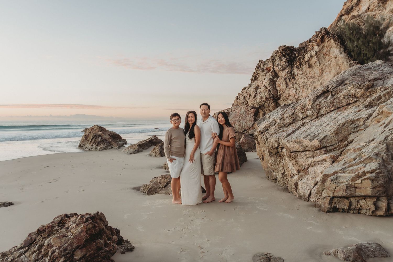 Happy family laughing together on a Gold Coast beach,parents and their three daughters enjoying a joyful moment at beach