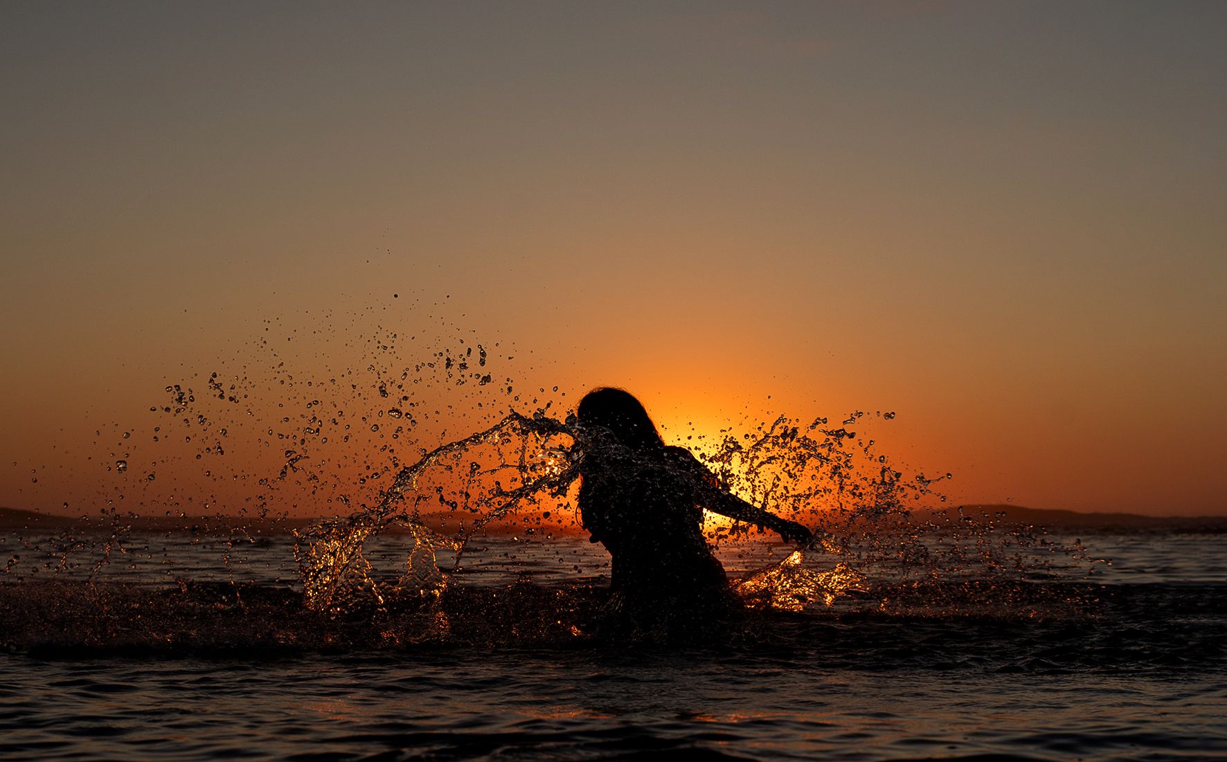 Sessão fotográfica de modelo na praia com por do sol