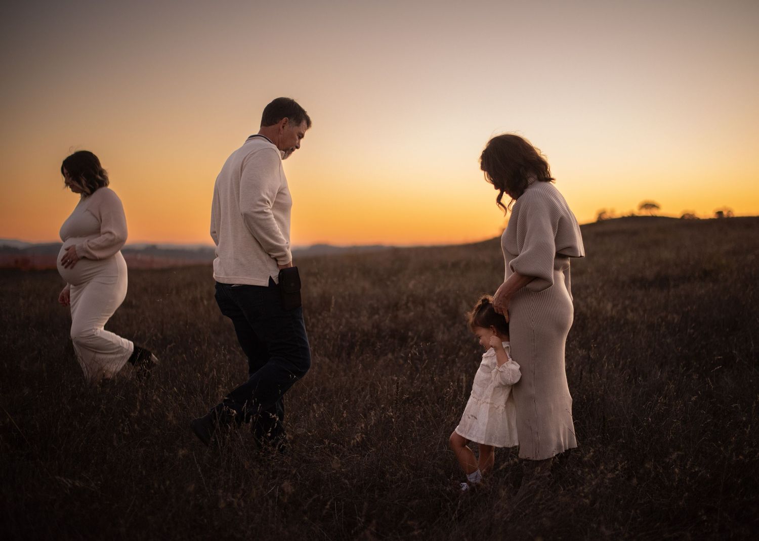 A family laughing and exploring together at Crane Creek, surrounded by open hills, tall grasses, and the beauty of Sonoma County.