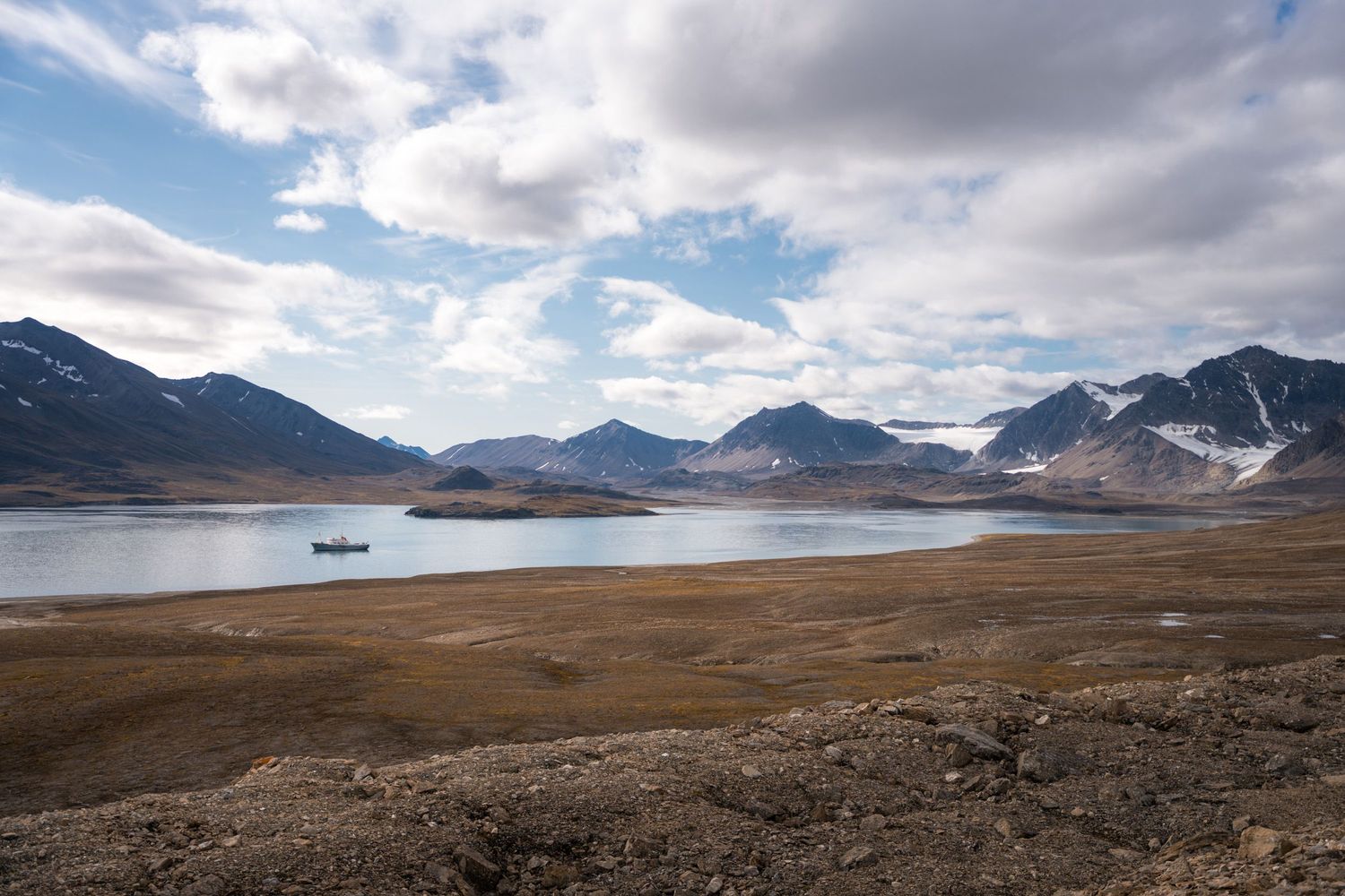 Le Polarfront au mouillage dans la baie de la Recherche, devant des montagnes enneigées