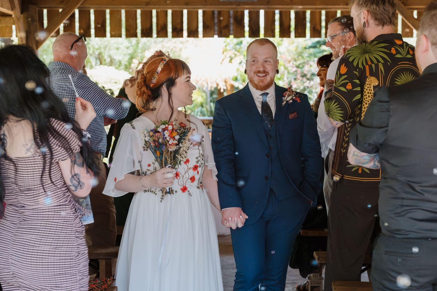 Rustic wedding sweetheart table with MR & MRS signs, The Henreys family name sign, and eucalyptus floral garland.