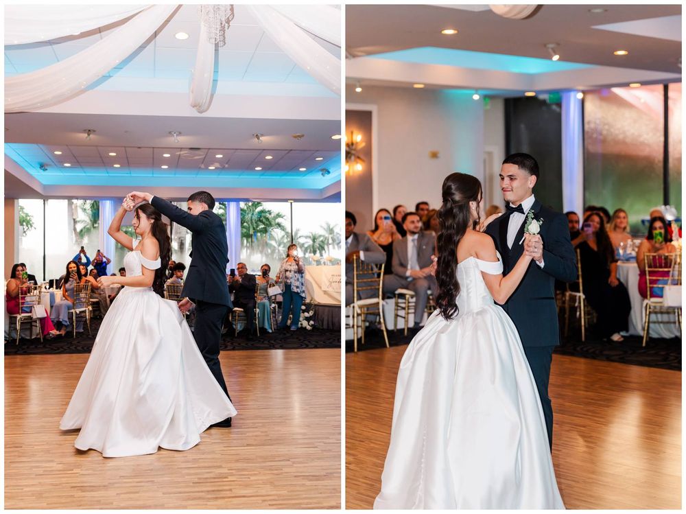 Bride and groom share romantic first dance in elegant ballroom with draped ceiling and blue ambient lighting.