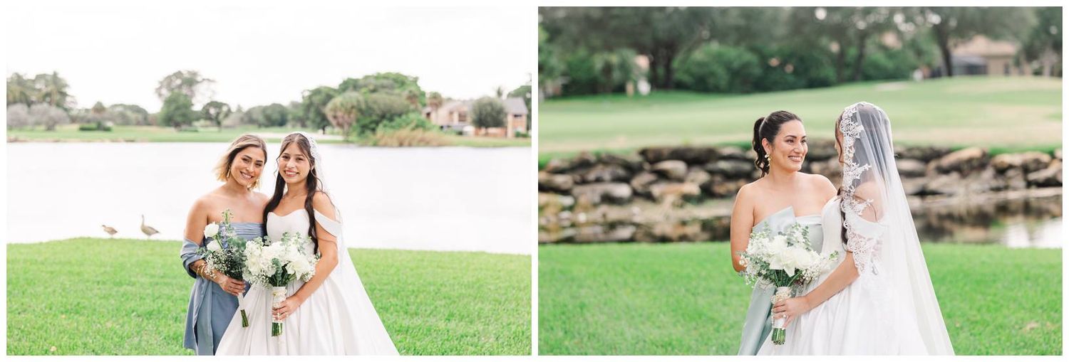 Bride and bridesmaid pose by a lakeside on a green lawn, both holding white bouquets in elegant white gowns.
