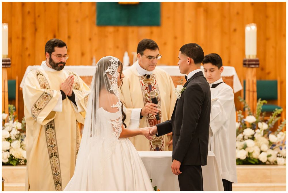 Bride and groom exchange vows at a church altar with priests officiating during a traditional wedding ceremony.
