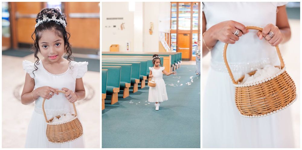 Young flower girl in white dress holding wicker basket at church wedding ceremony.