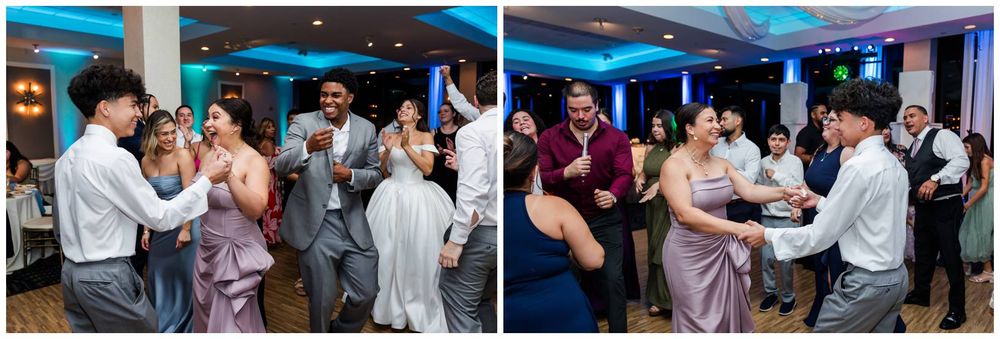Wedding reception guests enjoying lively dancing together under blue ambient lighting in the venue.
