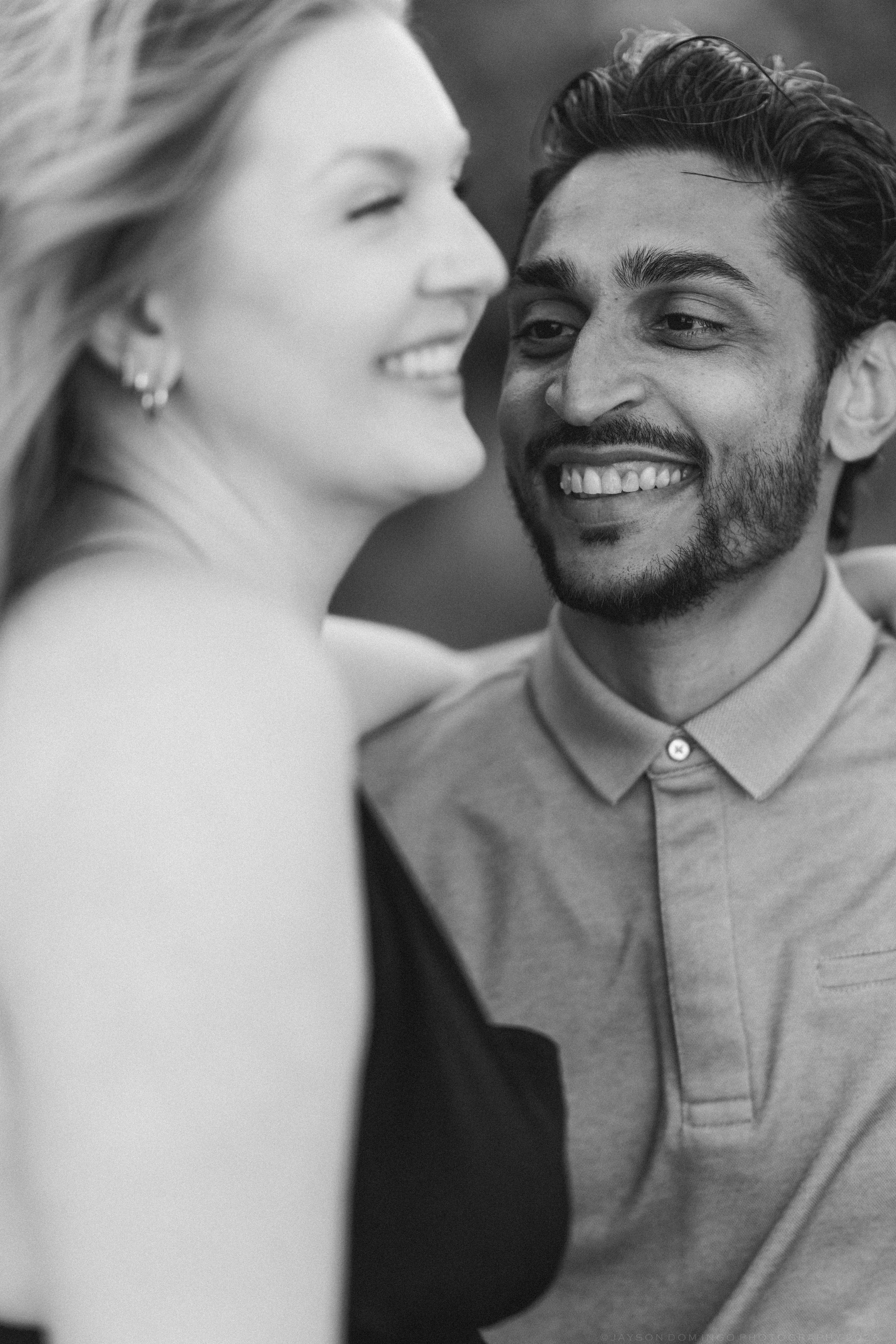 Black and white close-up of smiling couple sharing a joyful intimate moment together outdoors.