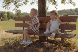 Glückliche Familie mit zwei Kindern bei einem natürlichen Familienshooting auf einem sonnigen Feldweg im Aargau.