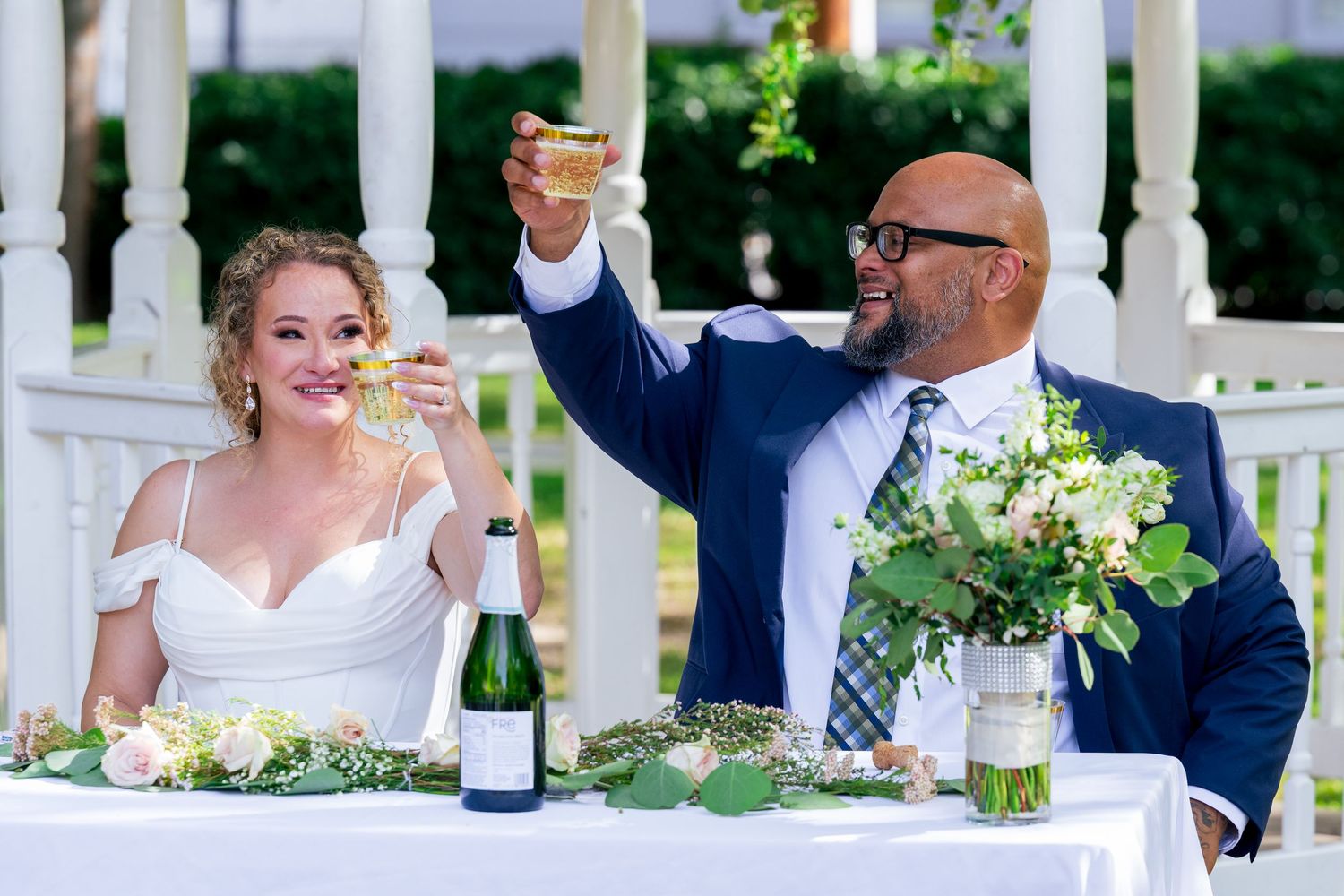 A photo of the bride and groom raising a glass of champagne to their friends and family after the wedding ceremony. Taken in LA