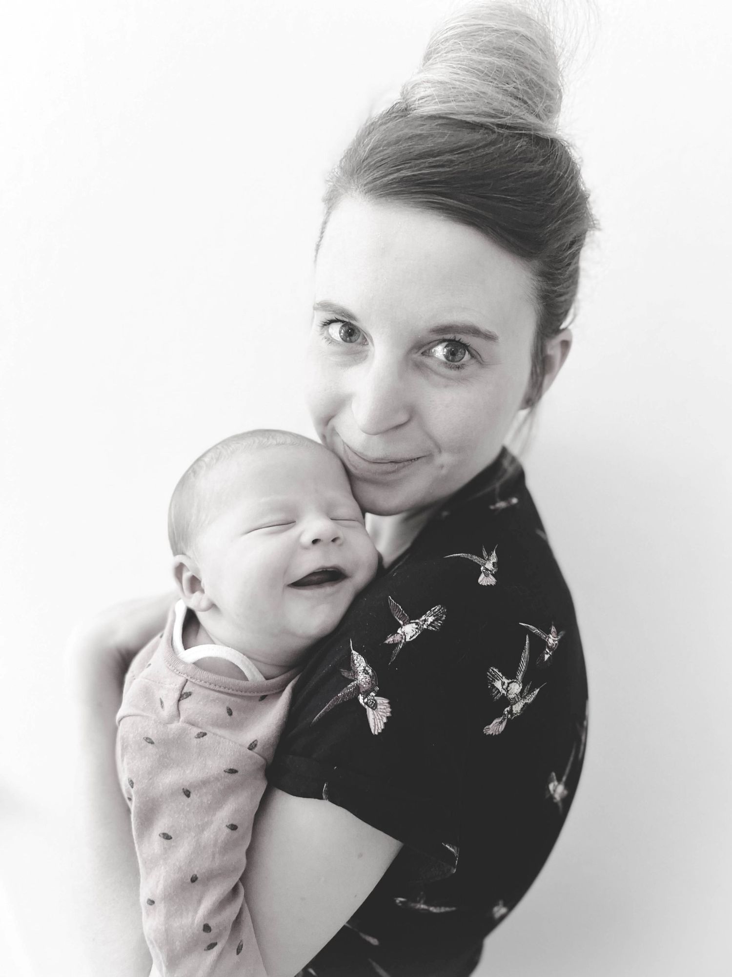 Amy, Brighton and Hove newborn photographer, holding a sleeping newborn baby