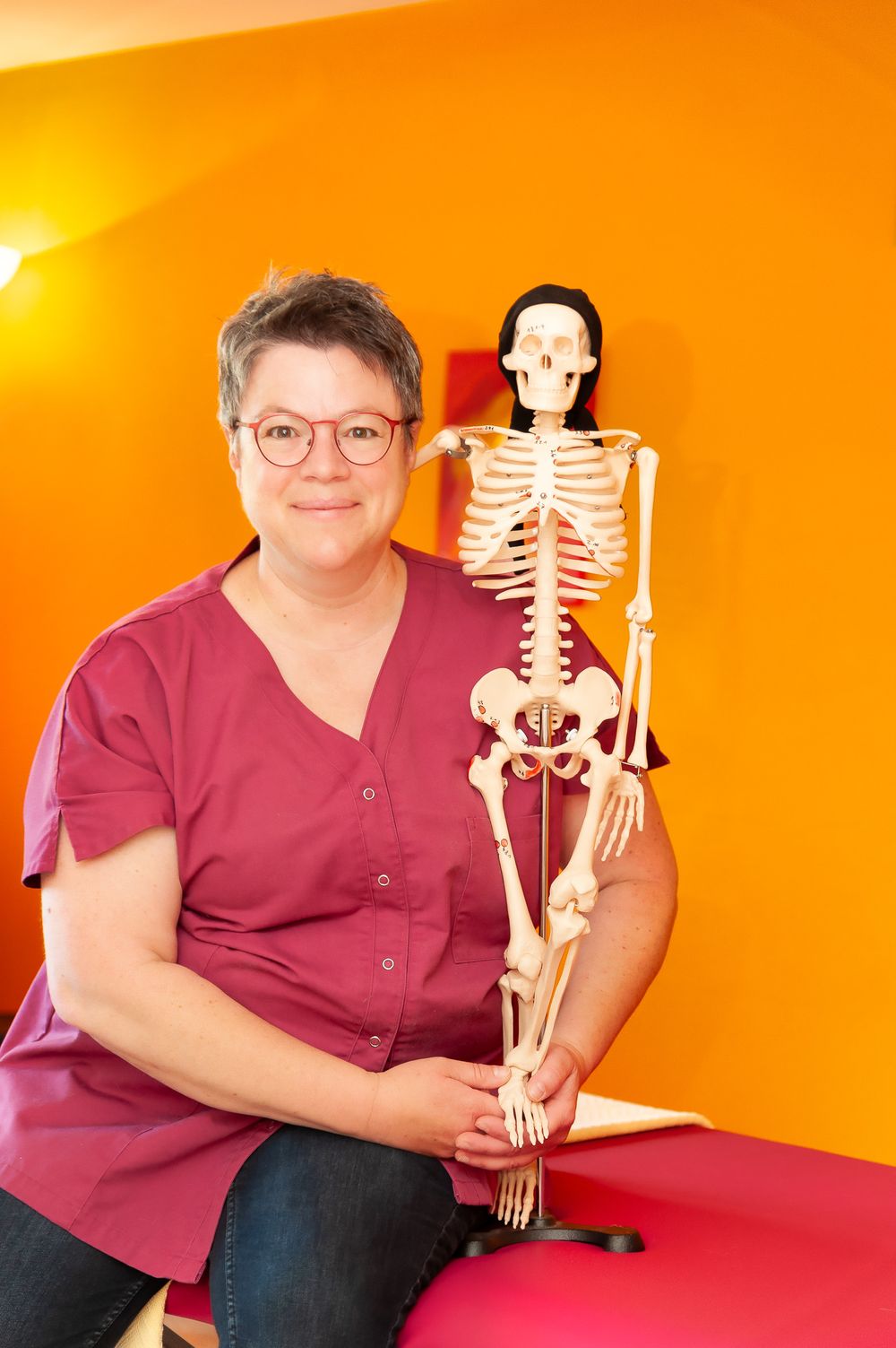 Physiotherapeutin Katrin Ritter in ihrer Praxis in Forchheim mit anatomischem Modell – Lichtkapsel Fotografie
