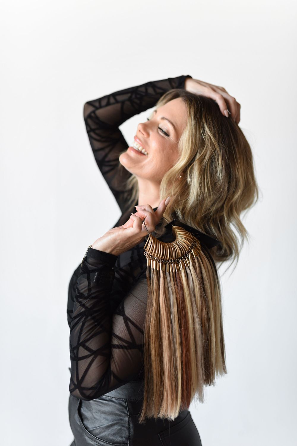 A hairstylist standing holding an extension ring during a branding session in a natural light studio.