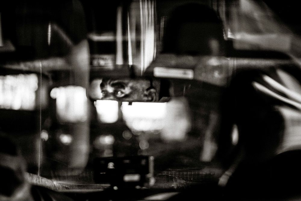 Abstract black and white close-up of an espresso machine brewing coffee in a cafe.