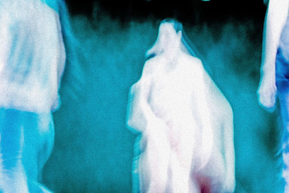 Blurry abstract art of ghostly figures in blue and white tones, creating an ethereal and mysterious atmosphere.