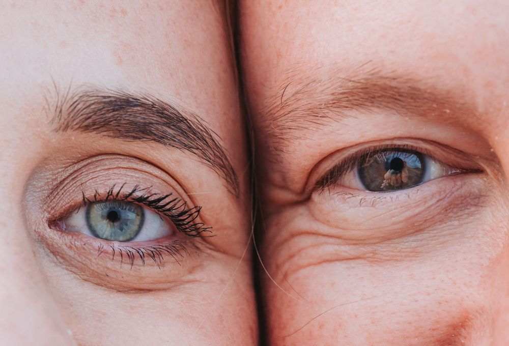 Close-up of two people's smiling eyes side by side, romantic detail shot of a pregnant couple