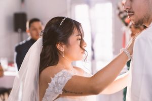Bride in white lace dress and veil shares first dance with groom at elegant wedding reception.