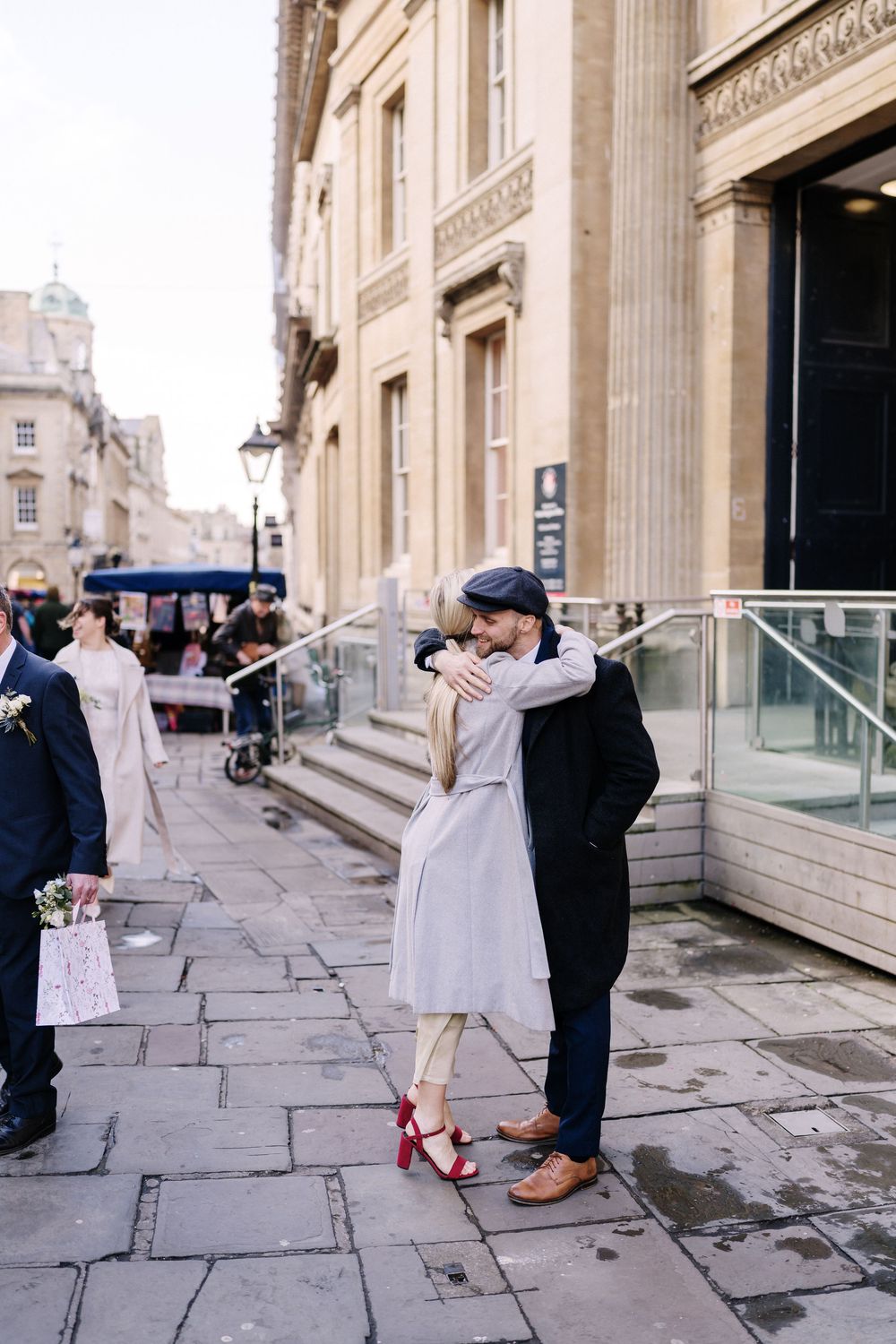 Couple embracing on a cobblestone street outside Corn Street Registry Office Wedding, Bristol,.