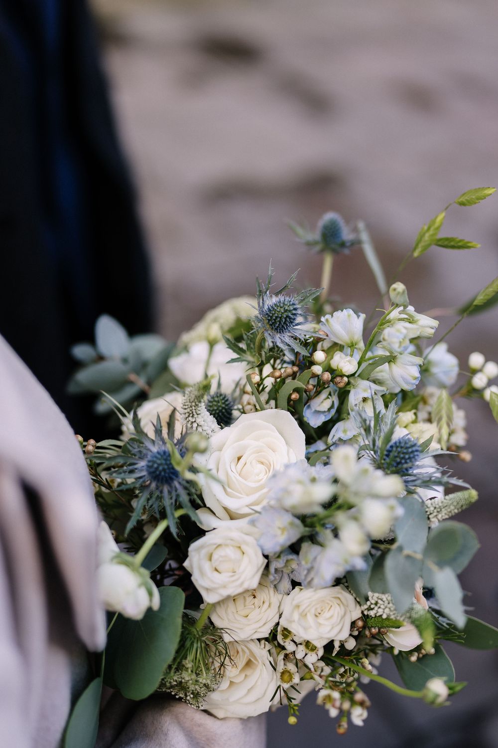 Bridal bouquet with white roses, blue thistle, and eucalyptus held by a bride in soft natural light for Corn Street Registry Office Wedding,
