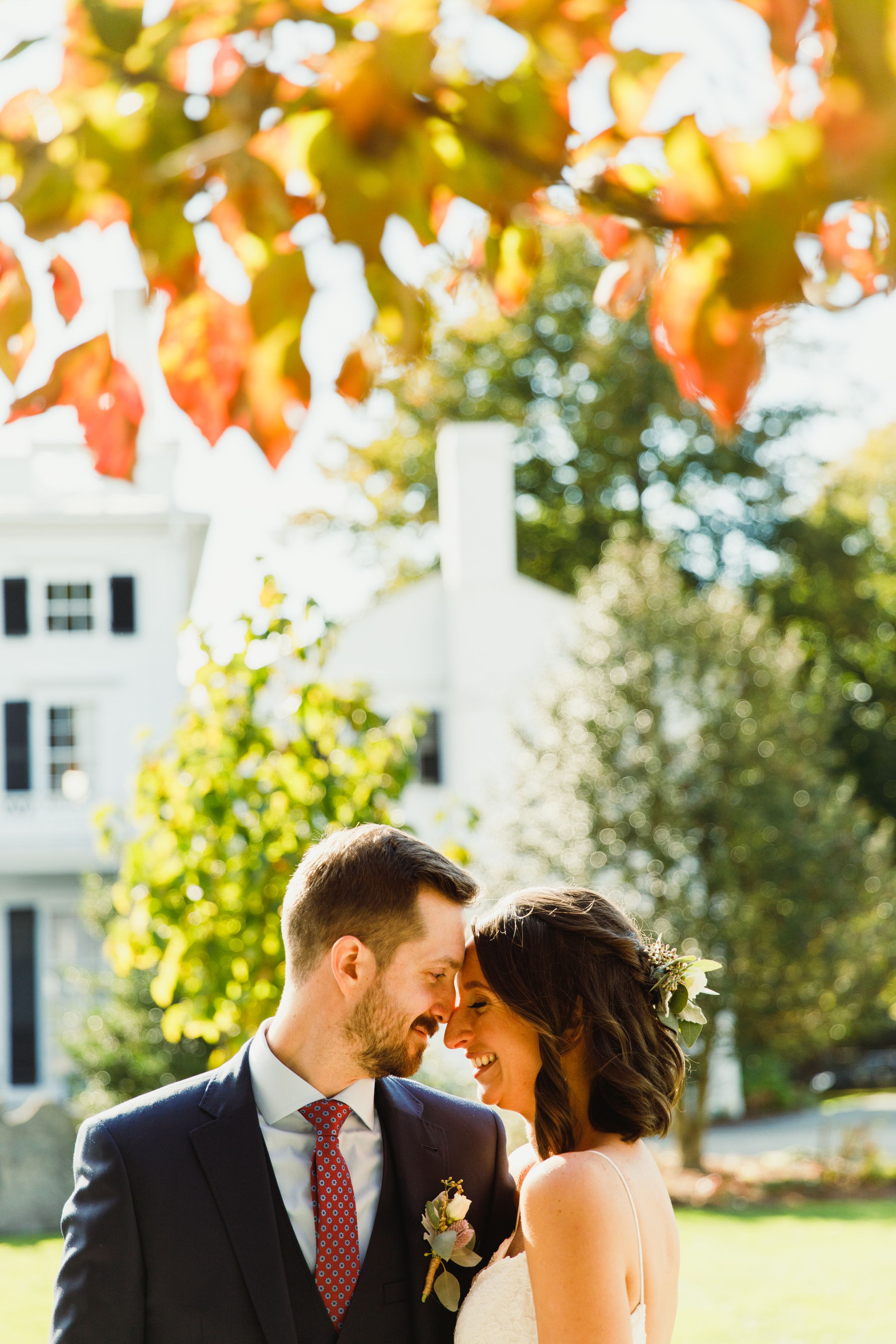 A romantic autumn wedding moment captured under golden leaves.