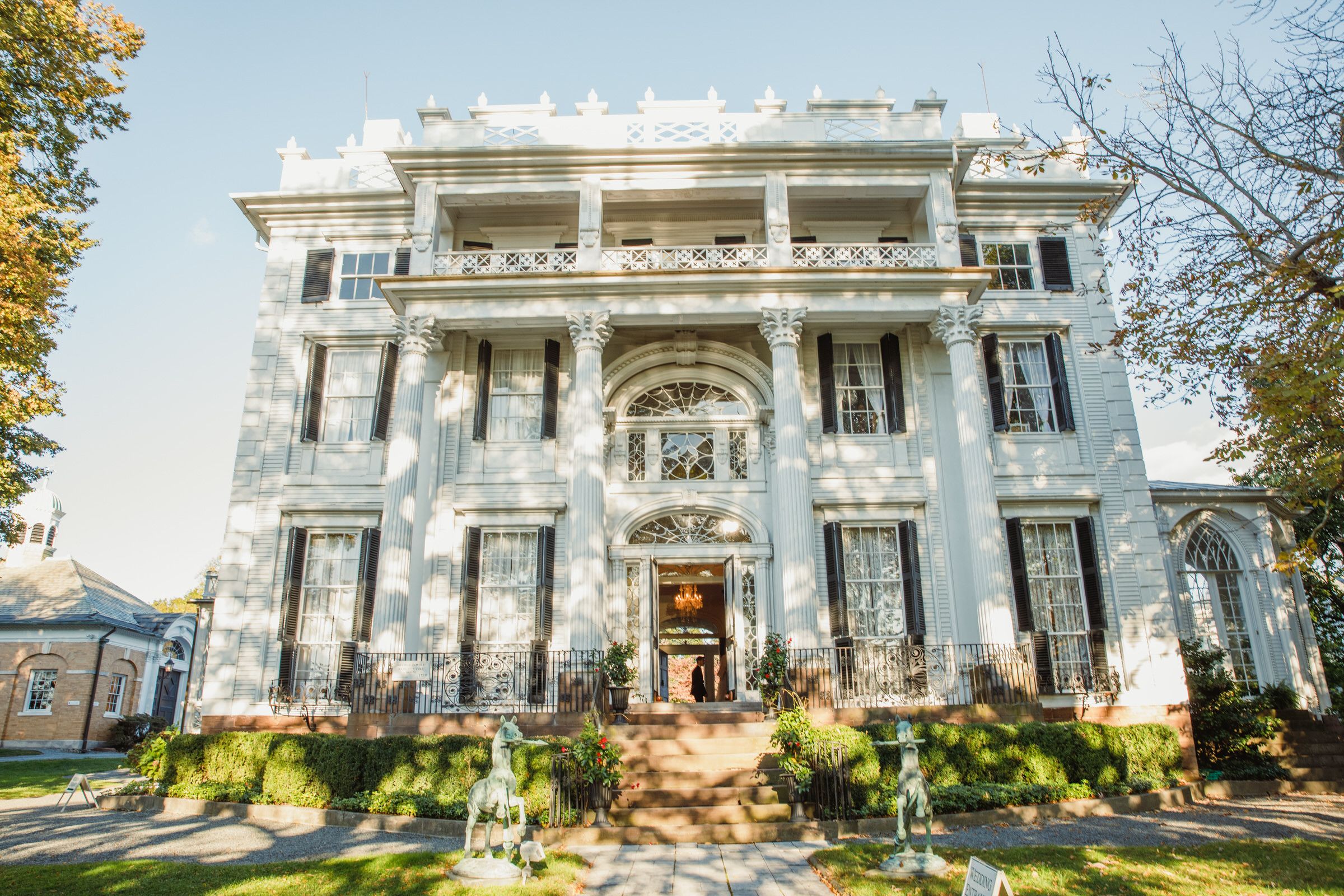 Majestic white antebellum mansion with ornate columns decorated for a special event.