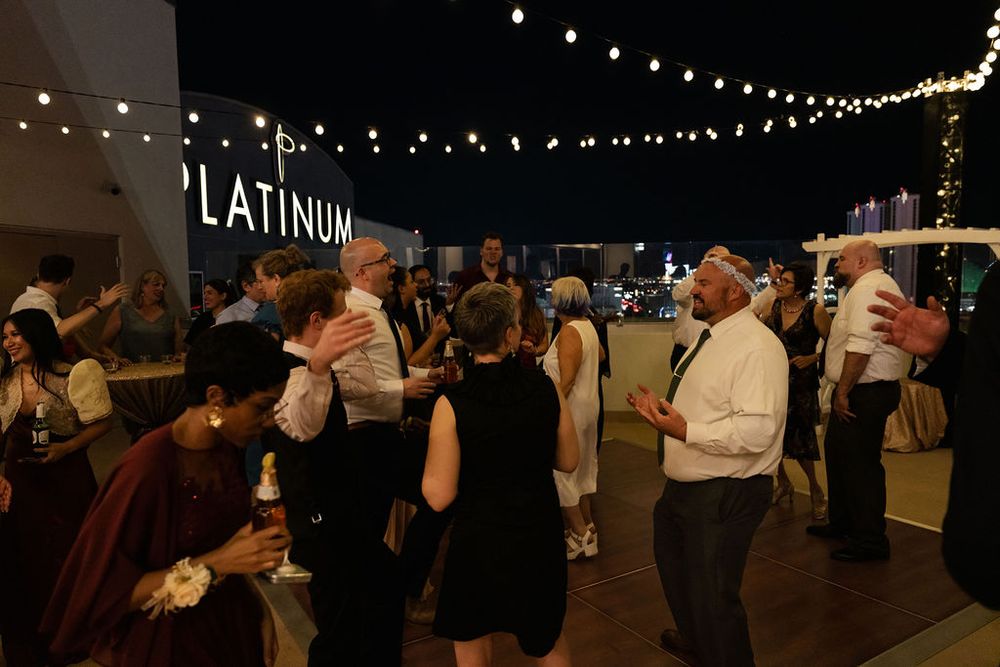Guests dancing at an outdoor rooftop event under string lights at Platinum venue during a nighttime celebration.