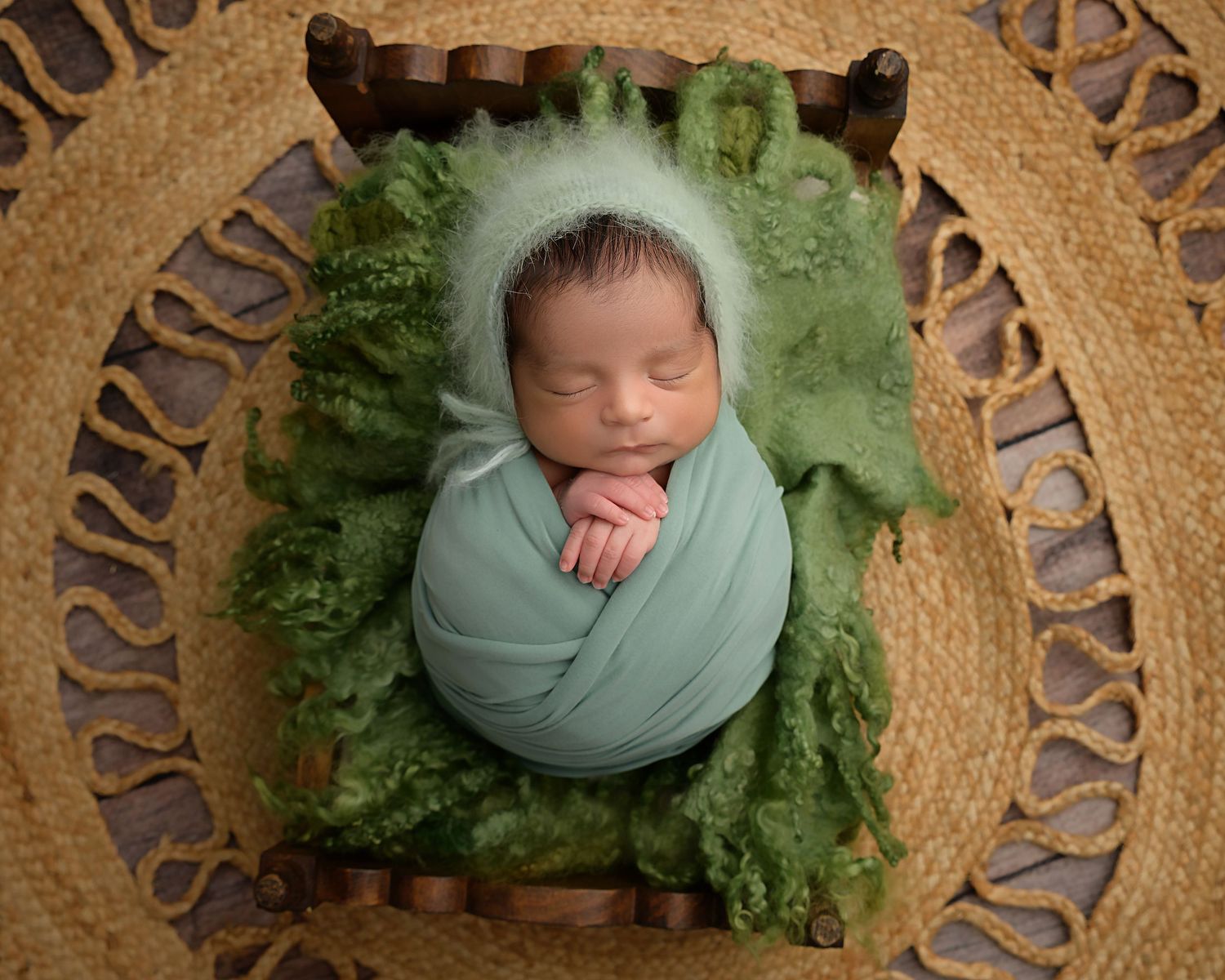 Baby wrapped in sage green during an organic newborn photography session near Tampa FL