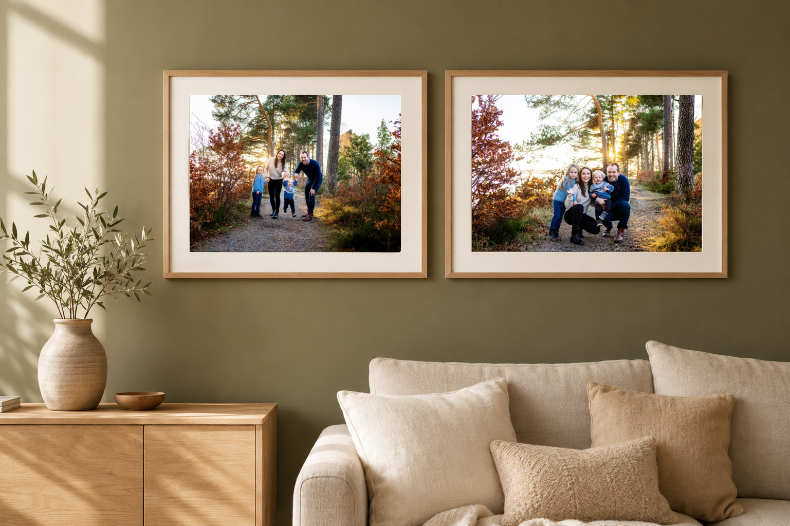 Two framed autumn family portrait photos displayed on olive green wall above beige sofa with wooden dresser beside it.