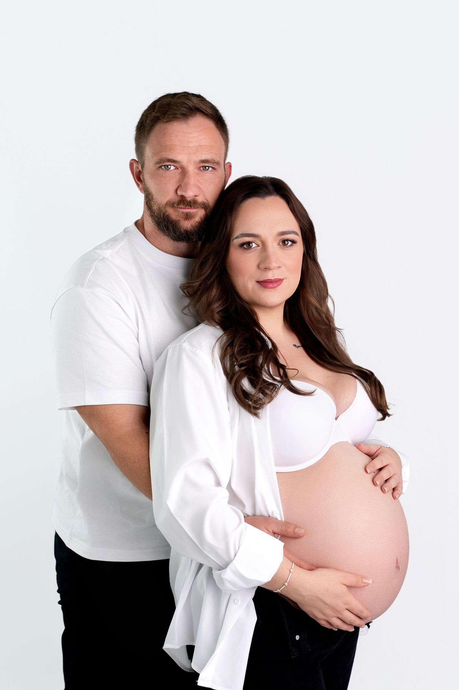 A series of artistic maternity photos showing a pregnant woman's silhouette against a dark background.
