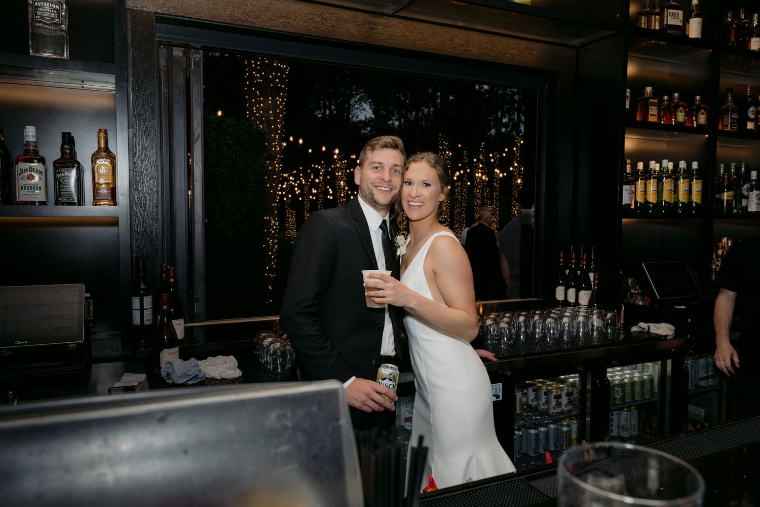 Bride & Groom stand behind the bar and cheers for an end of the night portrait at La Pointe Events in Somerset, WI.