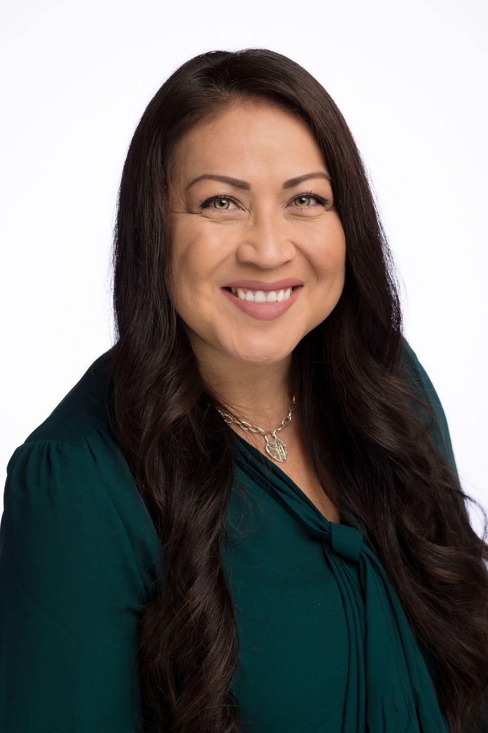 Professional headshot series showing a woman with dark hair wearing a green top smiling warmly against a white background.