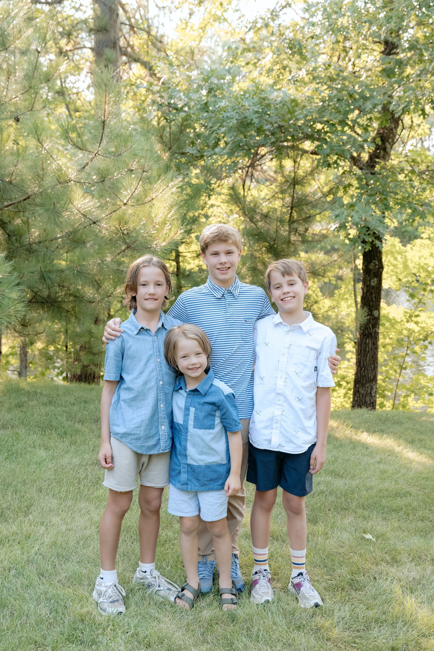 Kids only photograph of four brothers hugging and smiling during an outdoor family session in Holcombe, WI.