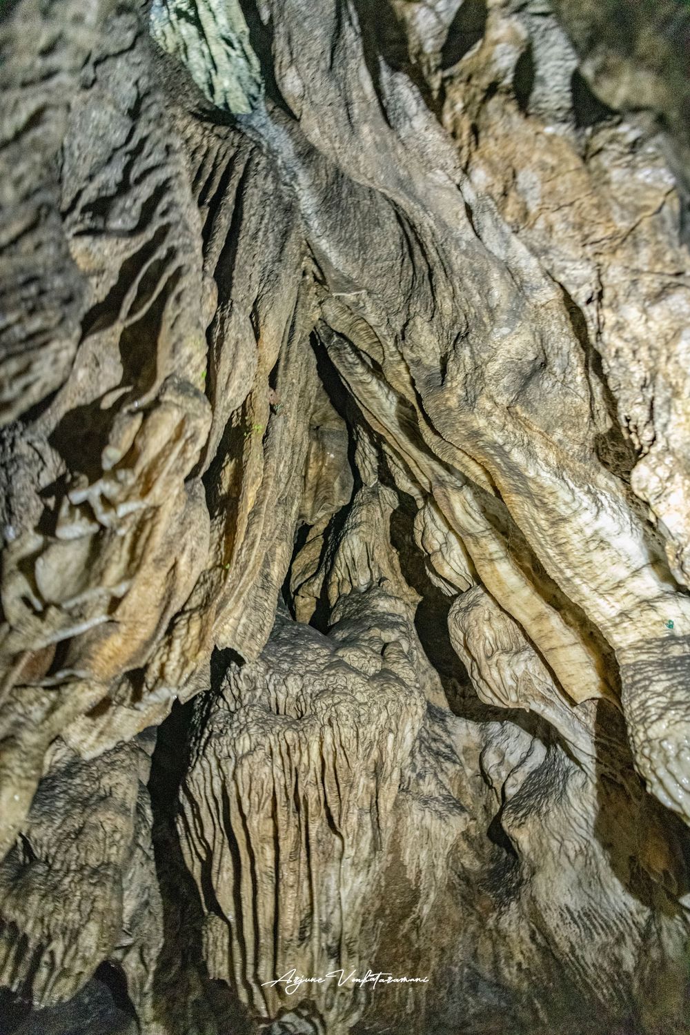 Close-up of intricate cave formations showing layered stalactites and textured limestone walls in a natural cavern.