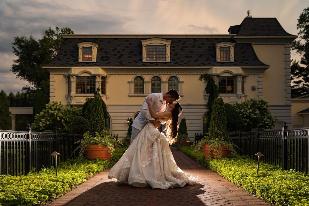 Groom dips the bride for a kiss at dusk on the garden path of The Ashford Estate, Allentown, NJ