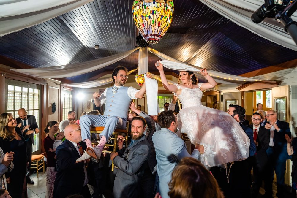 Bride and groom lifted on chairs during the hora at FEAST at Round Hill, Washingtonville, NY
