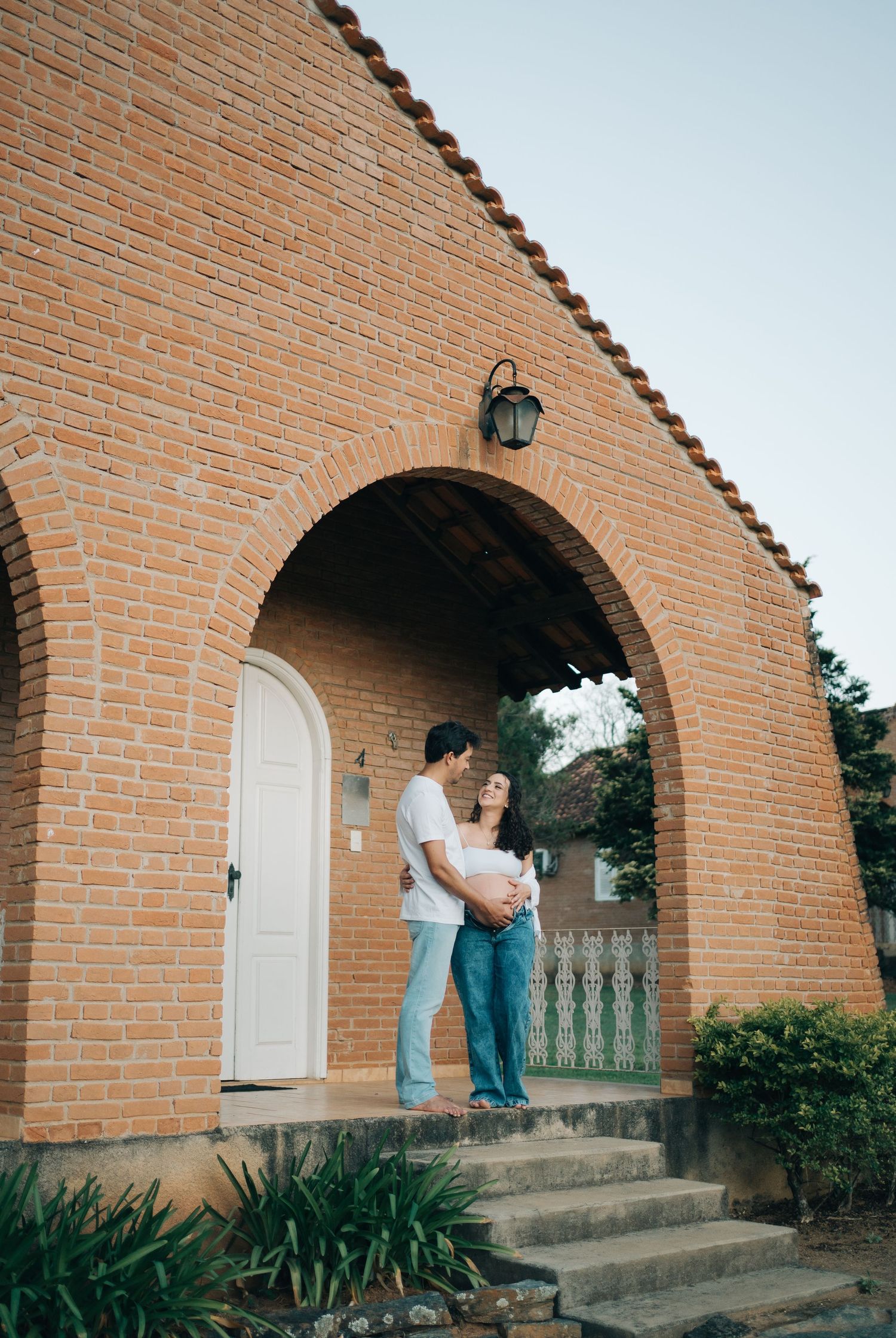 Liliana e Bruno sob o arco de tijolos da Fazenda Vintém, em Santa Rita do Sapucaí, no Sul de Minas.