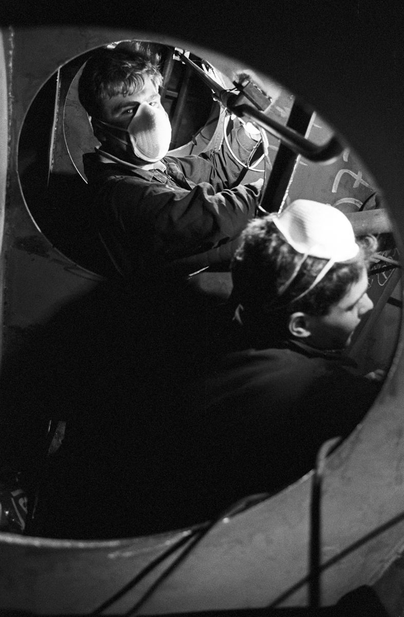 Photographie en noir et blanc d’un ouvrier portant un équipement de protection, photographié en hauteur sur un chantier. Docks du havre