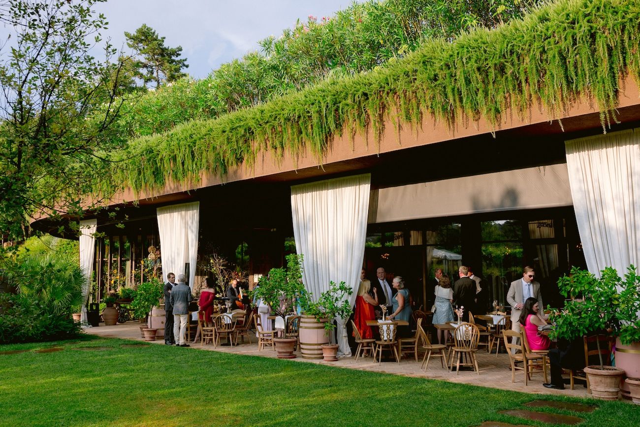 Guests enjoying welcome cocktails on the veranda of a wine bar before a Lake Garda rehearsal dinner