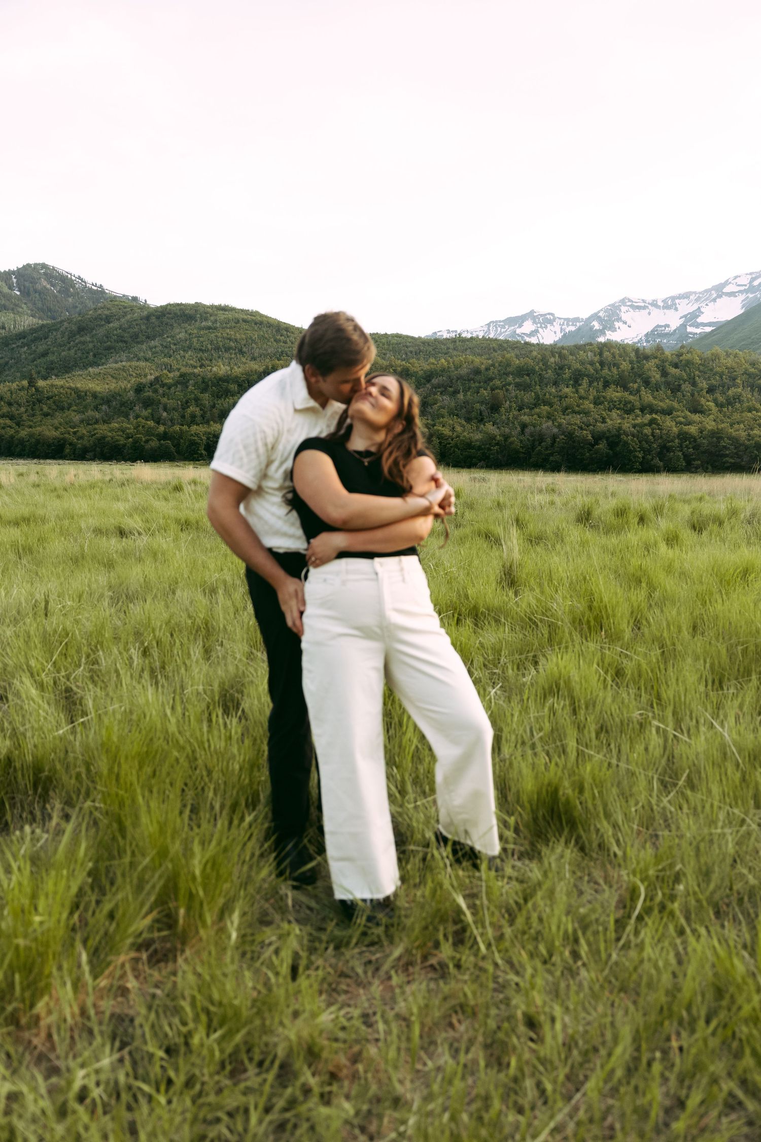 Attractive Biracial Hispanic and White couple featured in North Carolina Blue Ridge Mountain ivory and charcoal engagement picture outfits